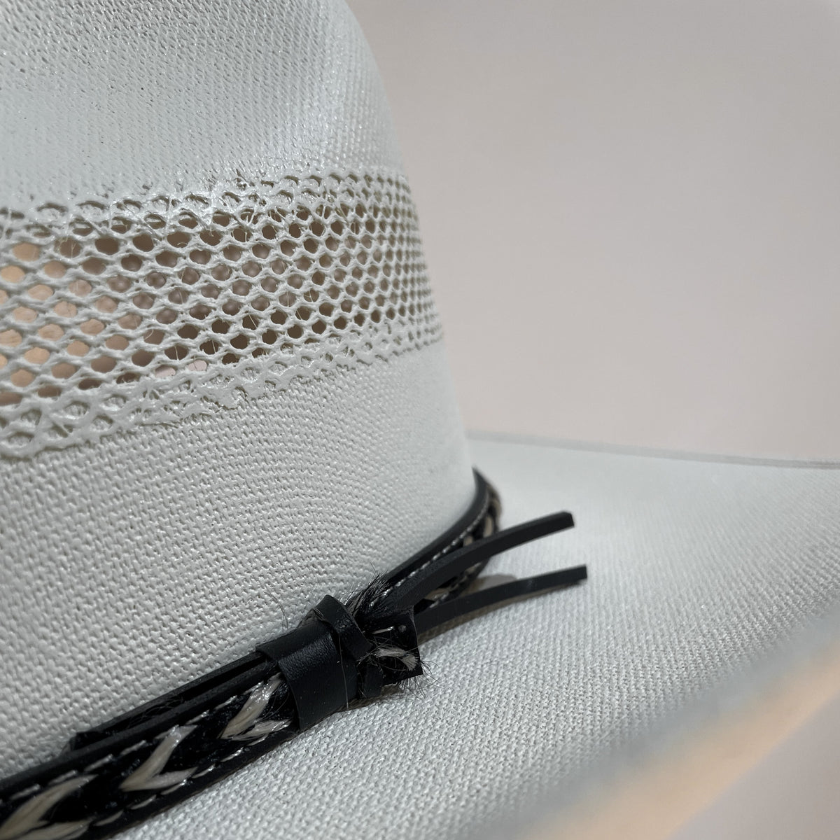 Closeup of the woven vent in the crown and the black leather hatband closure