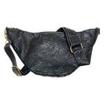 Back of black cow hair leather fanny pack showing adjustable tooled leather strap and gold-tone hardware. 