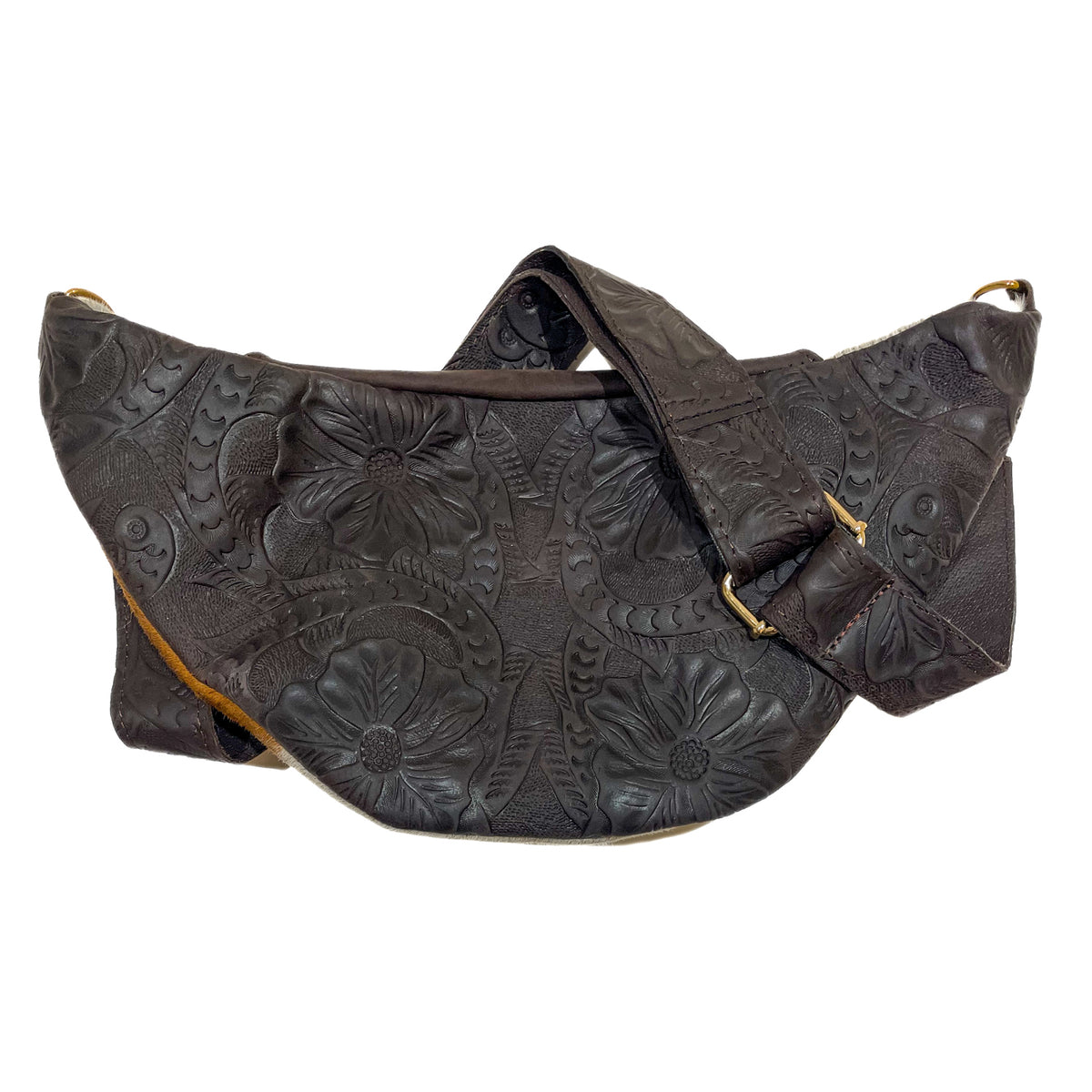 Back of brown cow hair leather fanny pack showing adjustable tooled leather strap and gold-tone hardware. 