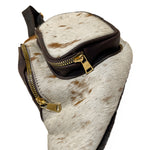Close-up of brown cow hair fanny pack showing front zippered pocket with genuine cowhide and leather trim. 