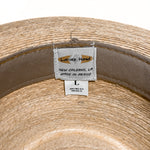 Close-up of the inside of a woven straw hat showing a sewn-in label that reads 'Latin's Hand' and 'New Orleans, LA Made in Mexico' alongside a size label marked 'L'. 
